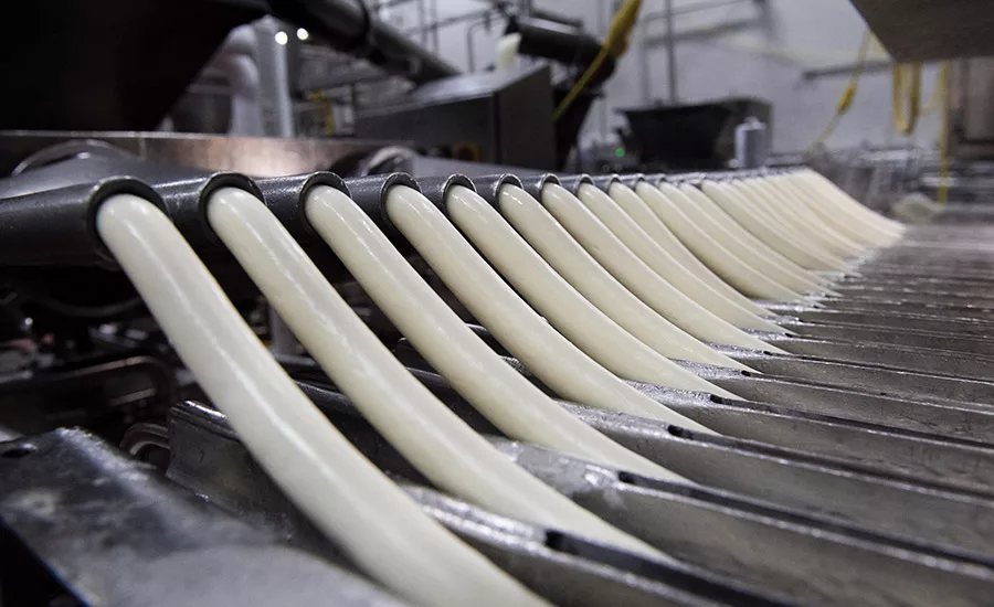 Baker Cheese’s products are formed into cheese tubes in one of nine extruders. They are then cut into individual string cheese pieces.