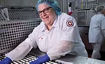 Packaging department employees fill in any cheese sticks that the automatic loaders may have missed.