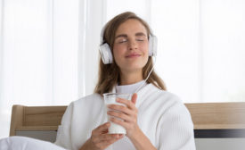 woman on headphone drinking milk