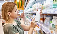 woman reviewing dairy products at the grocery store