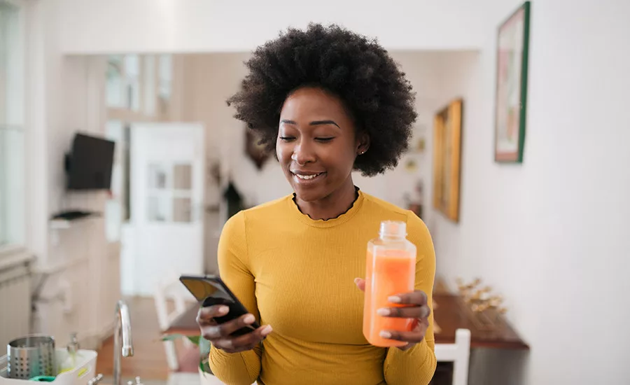 Woman drinking juice while on the phone