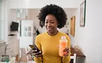 Woman drinking juice while on the phone