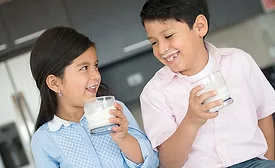 two kids drinking milk