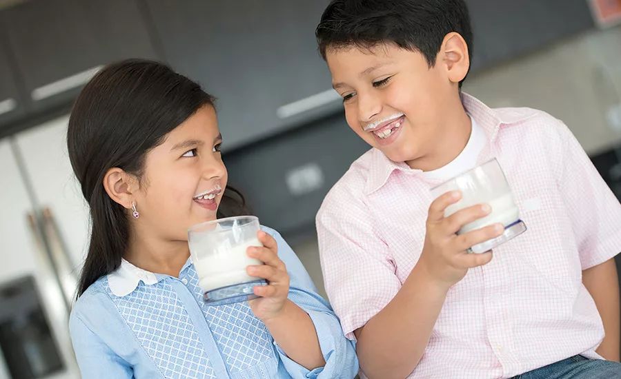 two kids drinking milk