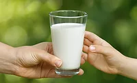 a person holding a glass of milk