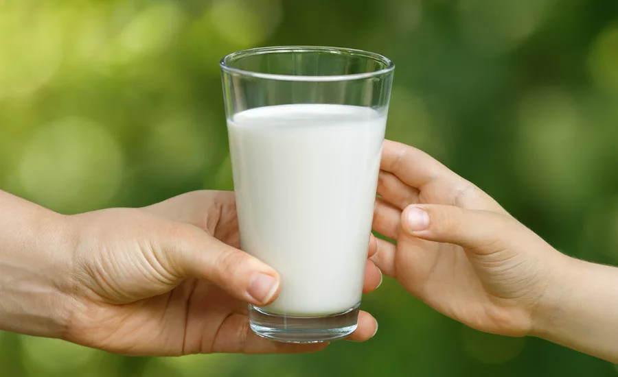 a person holding a glass of milk