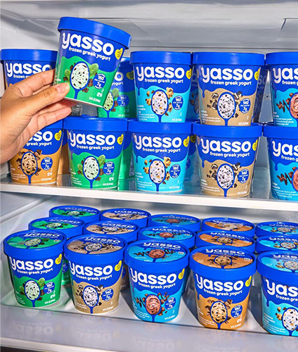 Hand putting Yasso spoonable frozen green yogurt in the freezer.