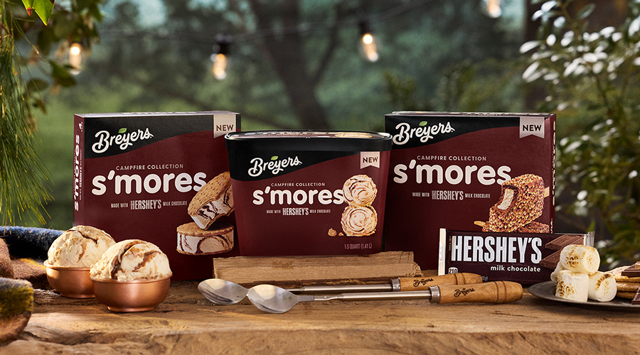 Breyers S’Mores Collection on a table, hershey bar, ice cream in a bowl, and spoons.