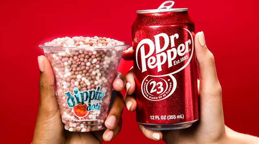 Hands holding Dippin' Dots and Dr. Pepper with a solid red background.