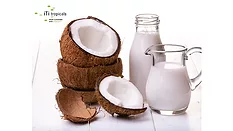 Glass botte and container of iTi Tropicals USDA-certified organic coconut cream next to a stack of open coconut shells.