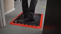 Person's feet on top of Magnattack Global's Magstride cleanable mat.