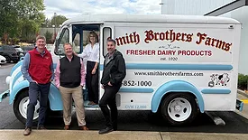 Left to right: Smith Brothers Farms CEO Dusty Highland, Vice President Todd Behan, Chief Growth Officer and Head of Home Delivery Michelle Hunt and Craig Koester posing in front a delivery truck.
