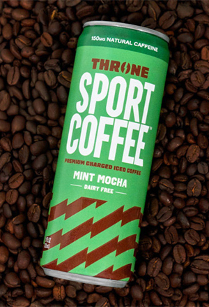A can of dairy free, Throne Sport Coffee in mint mocha flavor laying on coffee beans.