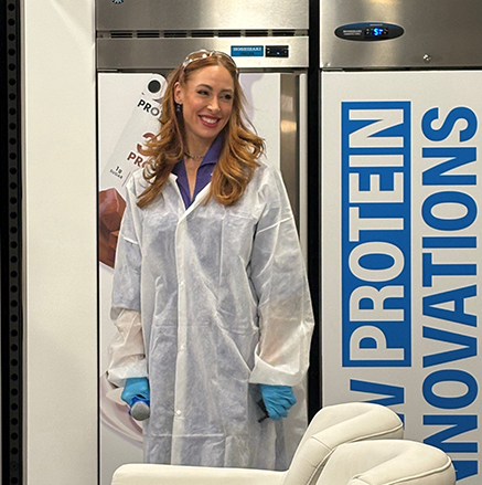 Emcee and Peloton fitness instructor Jess King dons a smock she wore following her visit to Danone's Pilot Plant at its headquarters.
