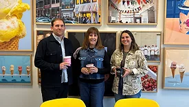 Left to right: Scott Hargove, Poe Timmons and Beth Stallings posing in front of Jeni's photos on the wall.