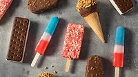 Ice cream and popsicles Variety of ice cream including ice cream sandwiches, popsicles, and ice cream bars laid out on a table.