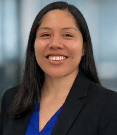 Nayely Isidro headshot with a blurred office background.