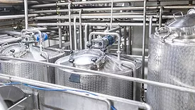 A close-up of storage and pasteurization equipment in a diary factory.