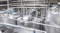 A close-up of storage and pasteurization equipment in a diary factory.