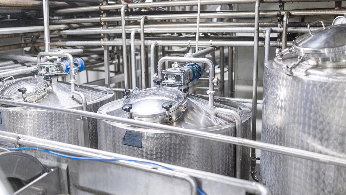 A close-up of storage and pasteurization equipment in a diary factory.