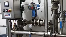 Industrial steam injection heating system with a control panel, stainless steel pipes, valves, and gauges.