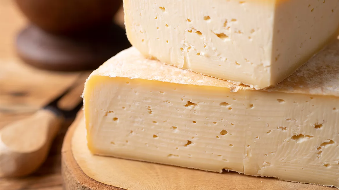 A close-up of stacks of cheese on a table with a blurred background.