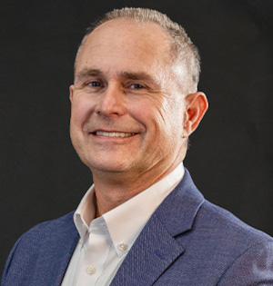 Headshot of Jon Cowell, CEO of Maola Local Dairies with a dark background.