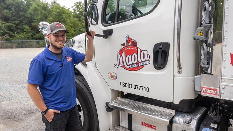 Maola Local Dairies truck drive posing next to his truck.