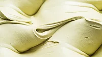 Close up of a whipped frozen dessert with a light green color.