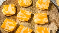Cheese and crackers on a round wooden board.