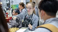 Expo Floor Young woman serving ice cream on a cone surrounded by other workers.