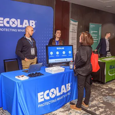 A discussion at an exhibitor booth at Membrane Technology Forum